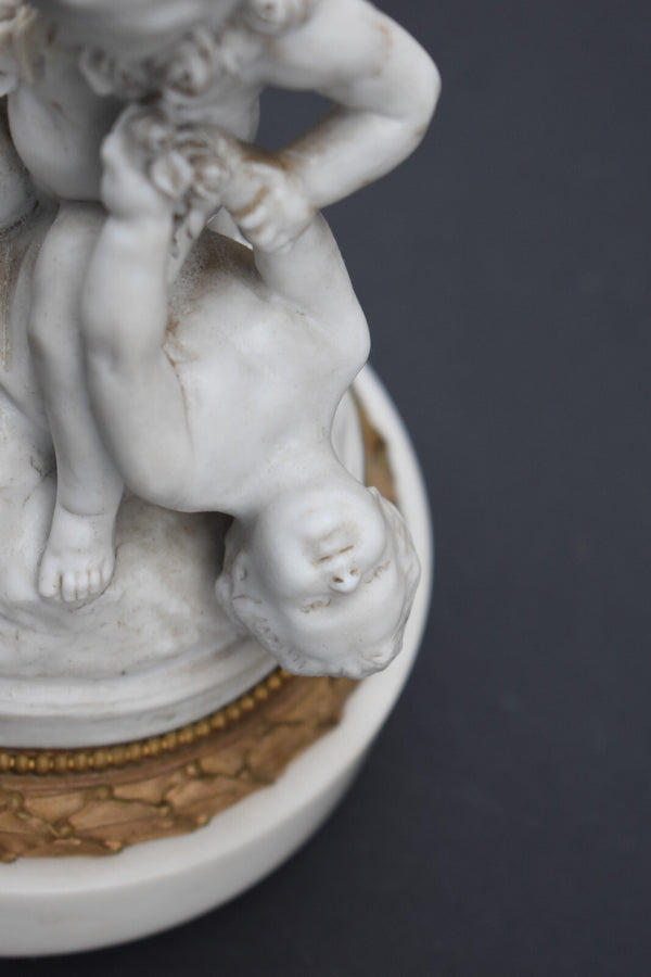 Antique bisque porcelain putti group statue playing marble base