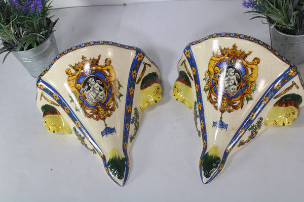 PAIR GIEN Faience mythological putti cherub scene caraytid head wall consoles