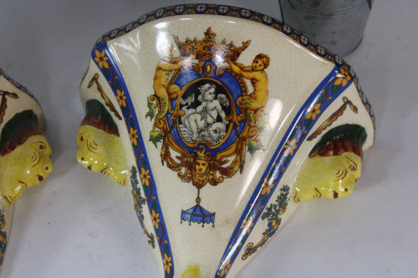 PAIR GIEN Faience mythological putti cherub scene caraytid head wall consoles